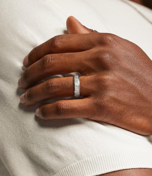 Model wearing a men's white gold wedding ring.