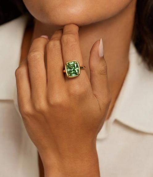 Model wearing a pacific green gemstone ring.
